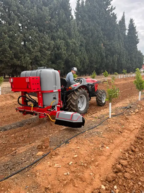 Tractor con barra herbicida de Mañez y Lozano en una plantación joven